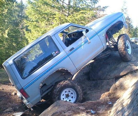 1984 Ford Bronco II - A silver Ford Bronco II navigates a rocky trail, its off-road capabilities.