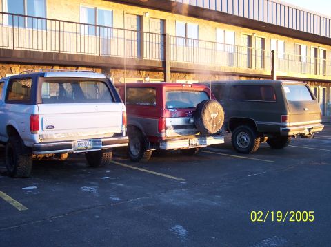 1995 Ford Bronco - Three SUVs are parked in a lot outside a building. The photo is dated 02/19/2005.
