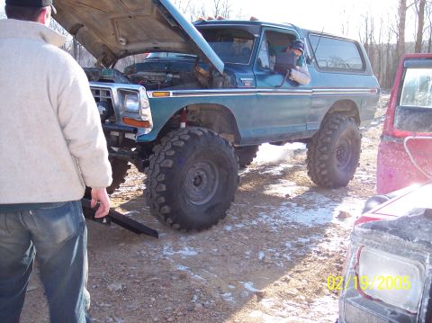 1995 Ford Bronco - Green Ford Bronco with hood open, being worked on. Another vehicle is nearby.