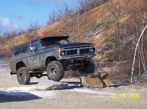 1995 Ford Bronco - This lifted Ford Bronco is navigating a rocky obstacle course on a sunny day.