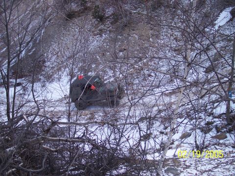 1995 Ford Bronco - An overturned 1992 Ford Bronco lies in a snow-covered area, surrounded by winter foliage.