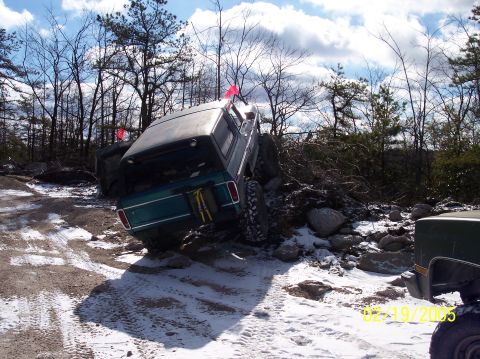 1995 Ford Bronco - A green 1980 Ford Bronco navigates a challenging off-road course with snow on the ground.