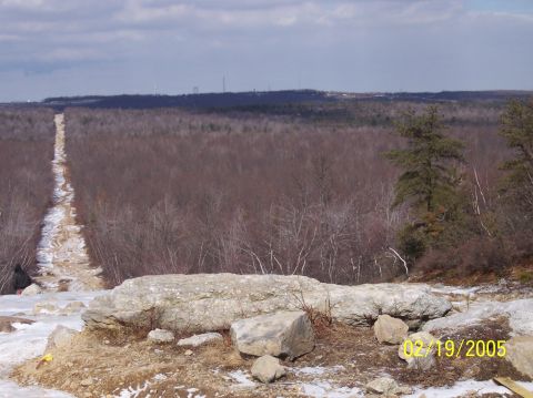 1995 Ford Bronco - A person is visible in the lower left of the frame, seated on a snowy embankment next to a dirt path.
