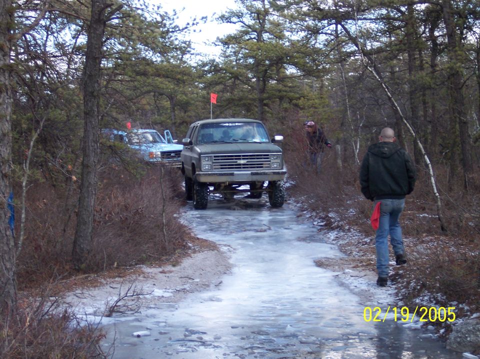 Green Chevrolet K5 Blazer with lifted suspension on an icy dirt road