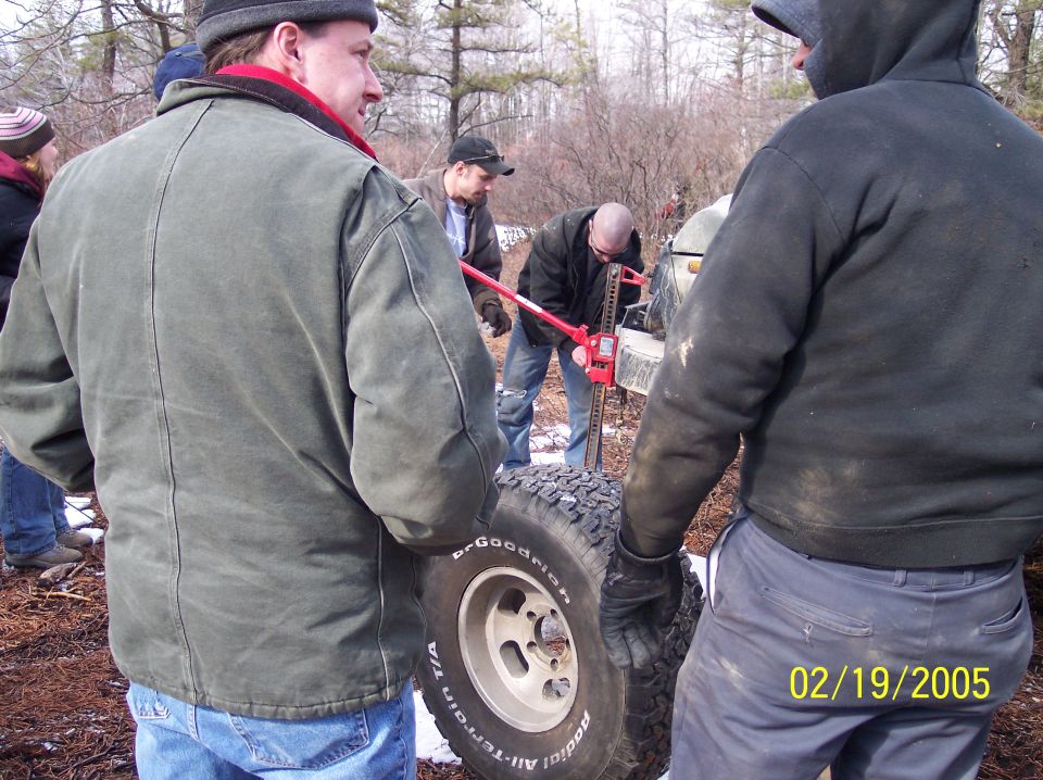 1995 Ford Bronco side view, people changing a tire
