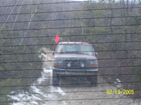 1995 Ford Bronco - 1995 Ford Bronco navigating a rough, off-road path with snow on the ground.