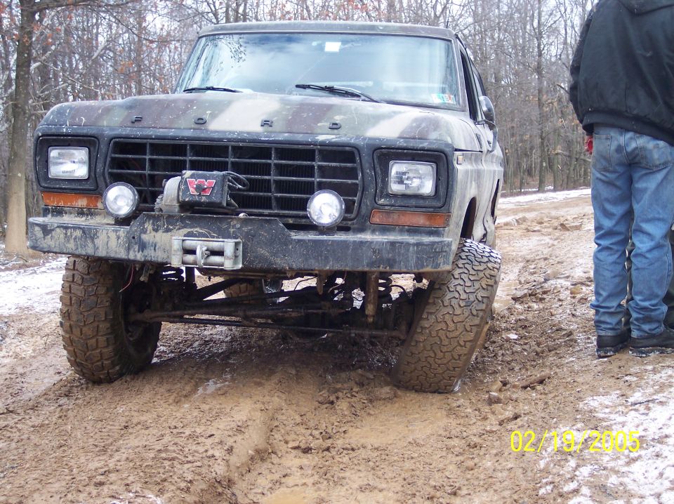 Muddy Ford truck with winch and auxiliary lights, front view. Camouflage paint