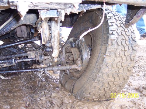 1995 Ford Bronco - The vehicle's suspension and tire are covered in mud, indicating it has been driven off-road.