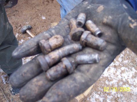 1995 Ford Bronco - A gloved hand holds several rusty lug nuts and bolts, with a date stamp visible in the corner.