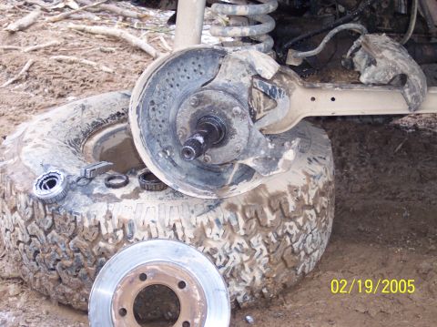 1995 Ford Bronco - A disassembled wheel hub and brake rotor are shown on the ground, with a date stamp of 02/19/2005 visible.