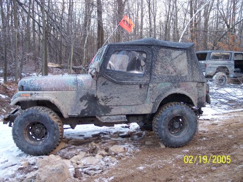 1995 Ford Bronco - Off-road Jeep CJ-7 covered in mud, with a second vehicle visible in the background.