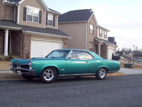 1967 Pontiac Lemans - A teal 1967 Pontiac Lemans coupe is parked in the driveway of a modern suburban home.