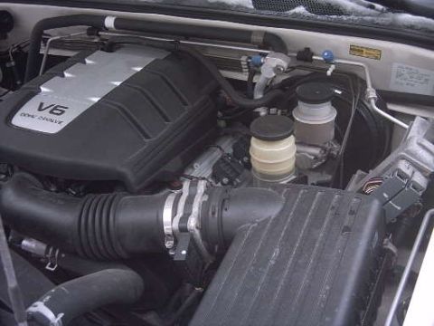 2000 Isuzu Rodeo - Engine bay of a 2000 Isuzu Rodeo, showing the V6 DOHC engine and associated components.