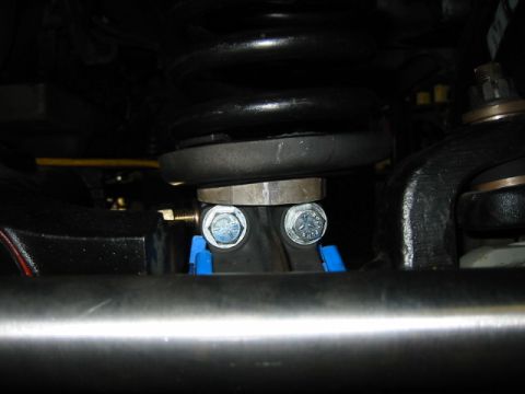 1992 Ford Bronco - Close-up view of vehicle suspension parts, including bolts and spacers.
