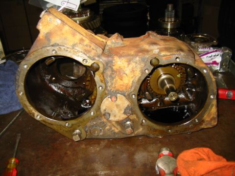 1992 Ford Bronco - A heavily used NP205 transfer case is shown disassembled on a workbench, revealing its internal gears.