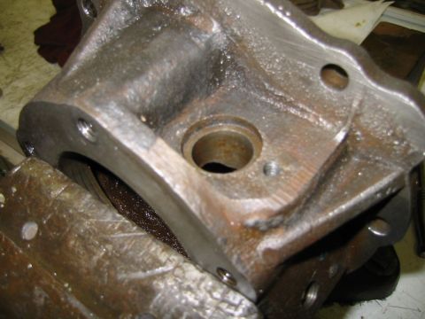 1992 Ford Bronco - A close-up view of a metal component, possibly a transfer case part, secured in a vise for work.
