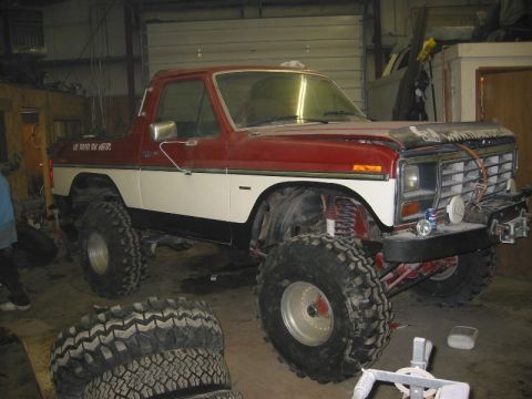 1985 Ford Bronco - This lifted 1985 Ford Bronco features a two-tone red and white paint scheme and aggressive off-road tires.