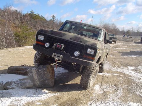 1995 Ford Bronco - Camouflage Ford Bronco tackles a challenging off-road course with one wheel lifted.