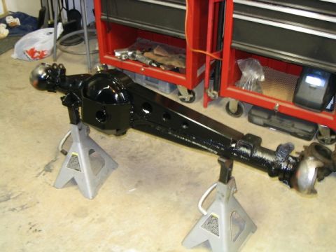 1986 Ford F-150 - A black rear axle assembly is supported by jack stands in a garage setting.