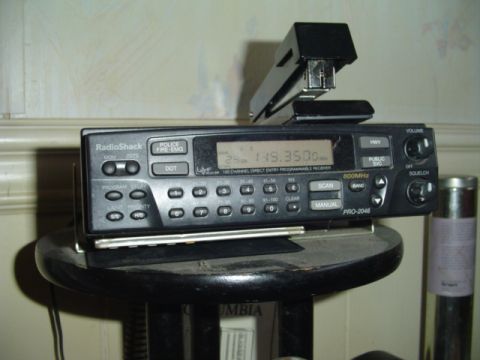 1993 Ford Bronco - A RadioShack PRO-2046 scanner is placed on a stool, with a stapler resting on its top surface.