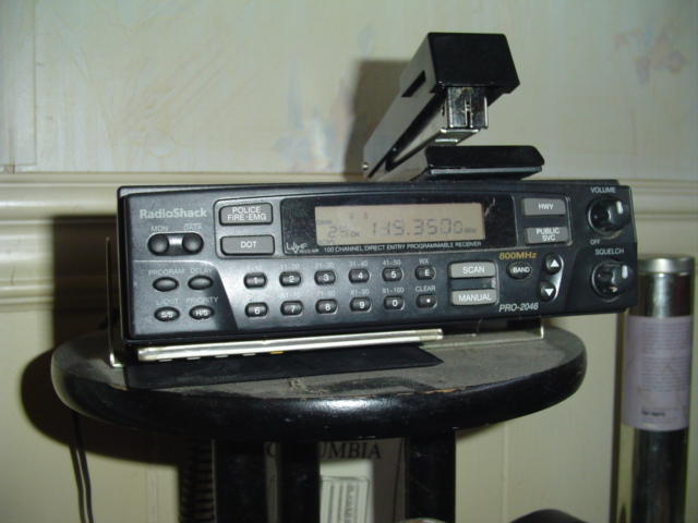 RadioShack PRO-2046 scanner with a stapler on top, sitting on a stool