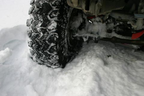2003 Jeep TJ - Off-road tire and suspension components visible in deep snow.