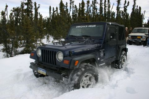 2003 Jeep TJ - Jeep TJ navigating a snowy trail with another vehicle in the background.