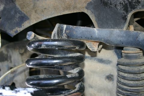 2003 Jeep TJ - Suspension components including a coil spring and shock absorber boot are visible.