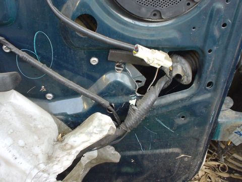 1993 Ford Bronco - Close-up of a vehicle's interior door panel showing electrical wiring and connectors.