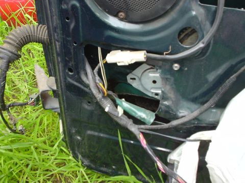 1993 Ford Bronco - Close-up view of the internal wiring and components of a vehicle door panel.
