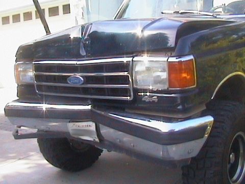 1991 Ford Bronco - The front end of a 1991 Ford Bronco shows damage to the hood and grille area.