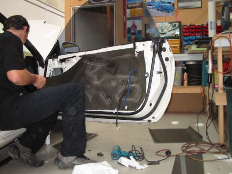 1994 Ford Probe - Car door panel removal in progress, with tools laid out on the garage floor.