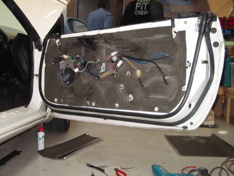 1994 Ford Probe - The interior of a white car door is shown with the door panel removed, revealing exposed wiring and insulation.