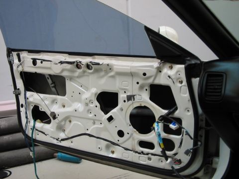 1994 Ford Probe - The interior of a car door is exposed, revealing its internal components and wiring harness.