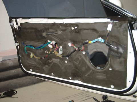 1994 Ford Probe - Interior of a car door panel removed, revealing the wiring and insulation. No year or make is visually identifiable.