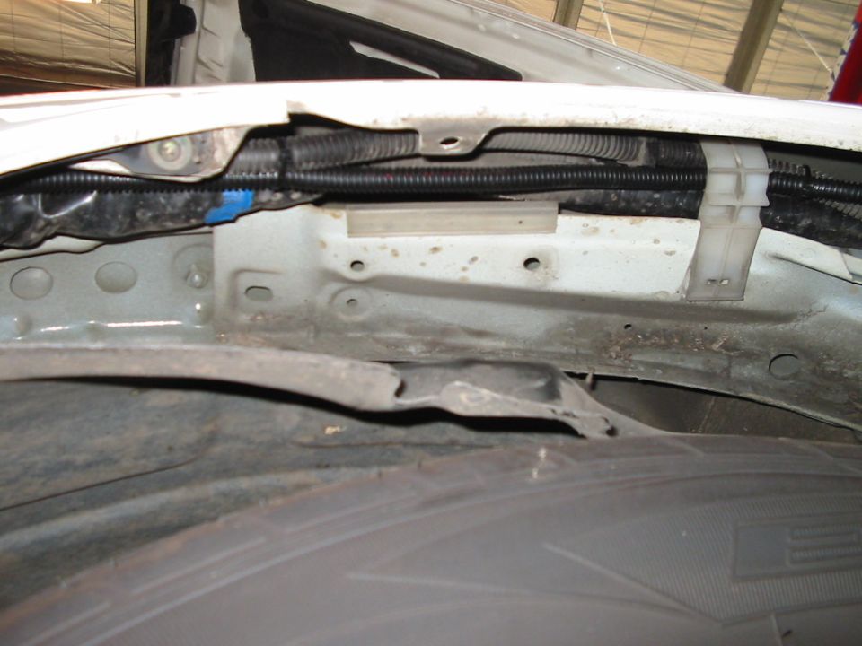 Close-up of wheel well and fender liner with wiring harness
