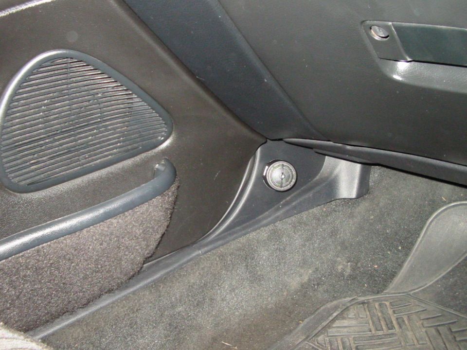 Car interior shot showing a speaker grille and a lock cylinder near the dashboard
