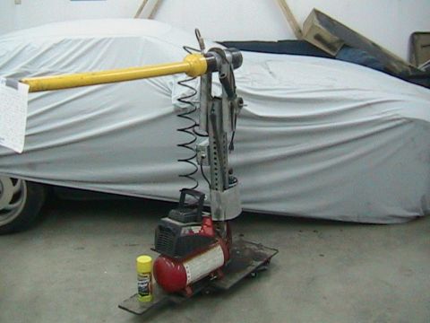 1981 Chevrolet C/K Pickup - Automotive repair tool with air compressor in front of a car covered by a tarp.