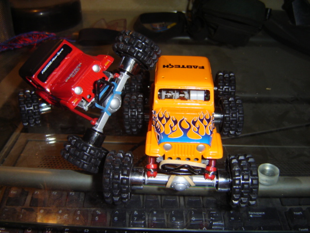 Orange and red remote control toy trucks on a keyboard