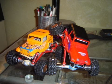 1992 Ford Bronco - A pair of remote-controlled off-road trucks are captured in a playful, dynamic arrangement.