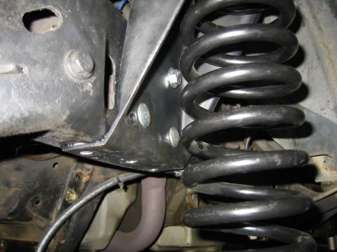 1992 Ford Bronco - Close-up view of a suspension coil and its mounting bracket, likely part of an aftermarket upgrade.