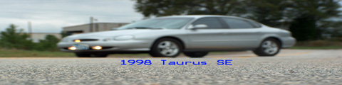 1998 Ford Taurus - A silver 1998 Ford Taurus SE is seen from a low angle on a paved surface.