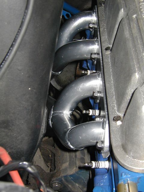 1968 Ford Mustang - Engine exhaust headers and spark plugs are shown in this close-up view.