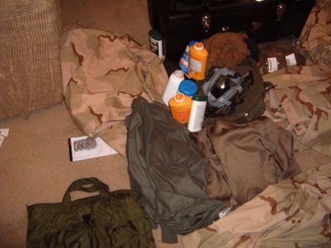 1988 Ford Bronco - Various items including military clothing and cleaning supplies are spread across the carpeted floor.