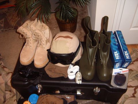 1988 Ford Bronco - A collection of military-style gear and personal items are arranged on a black case, suggesting preparation for a trip or deployment.