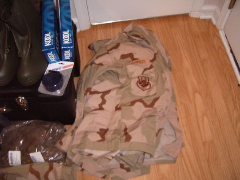 1988 Ford Bronco - A desert camouflage uniform is laid out on a wooden floor next to boots and other items.