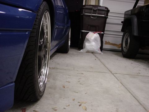 1998 Volkswagen Jetta - A blue sedan and a black Jeep are parked in a garage, with storage bins and a trash bag nearby.