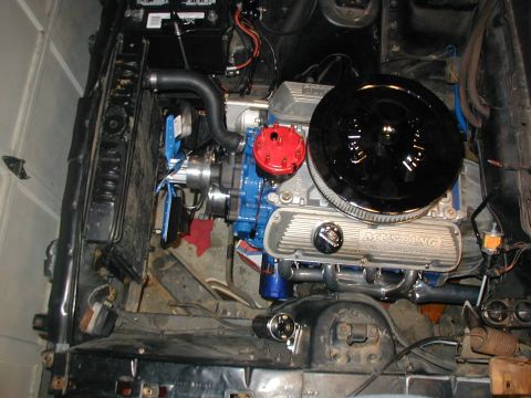 1968 Ford Mustang - The engine bay of a 1968 Ford Mustang features a V8 engine with chrome valve covers and a prominent air cleaner assembly.