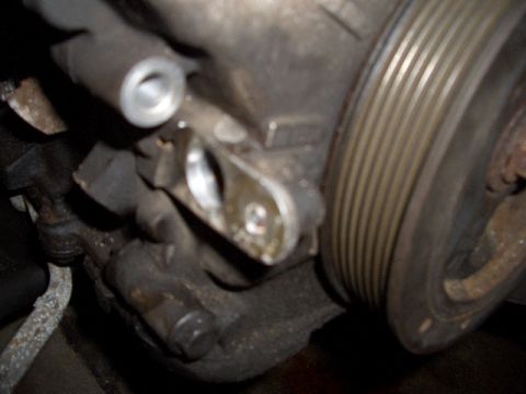 1992 Ford Crown Victoria - Close-up view of an engine component with a ribbed pulley and visible bolts.