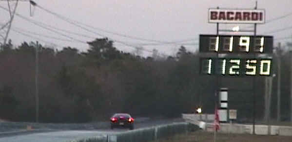 Red sports car at drag strip with '11.91' displayed on scoreboard